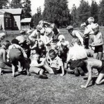 Seinäjokelaislapset leikkimässä herneidenkeruuleikkiä kesäkaitsijansa silmien alla. 