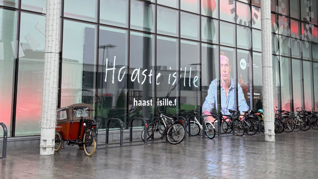 Haaste isille -kampanjakuva kauppakeskuksen seinällä