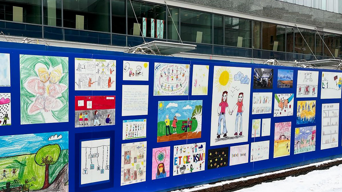 Lasten piirustuksia työmaa-aidassa